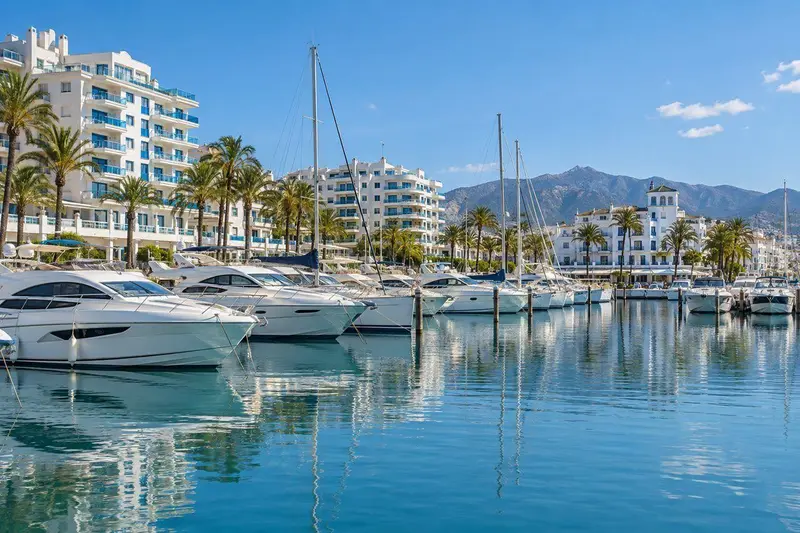 Puerto deportivo de Estepona con barcos blancos y edificios modernos bajo un día soleado