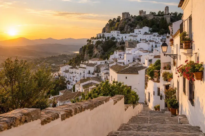Pueblo blanco de Casares sobre una colina al atardecer, con calles encaladas y luz cálida
