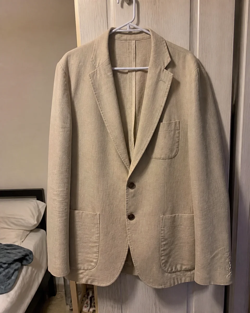 Foto original de una americana beige colgada